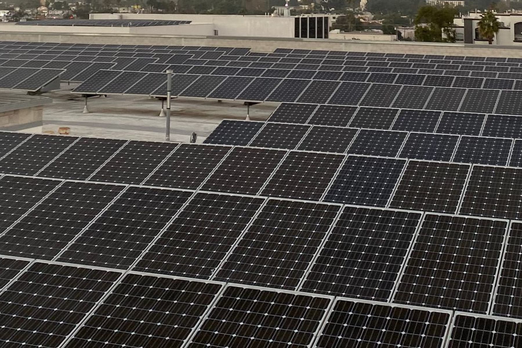 Large solar array covering a commercial flat roof at dusk
