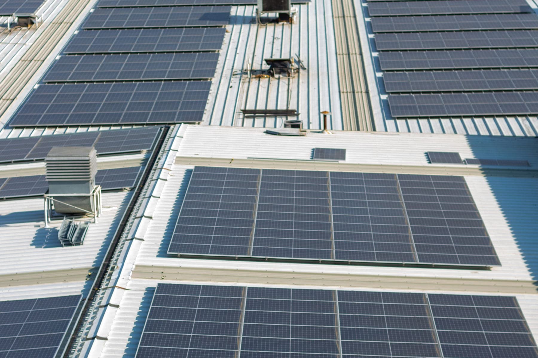 Rooftop solar arrays laid out across an industrial building
